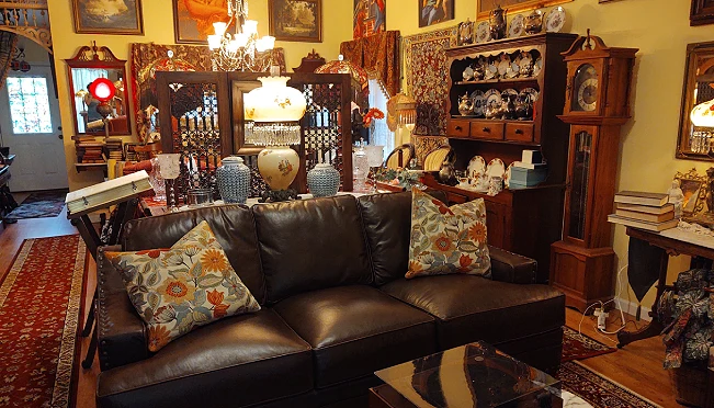 Maximalist living room filled with antique furniture, china cabinets, and collections everywhere